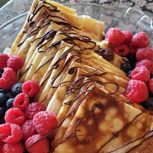 Pancakes with blueberries,strawberry, and chocolate drizzle